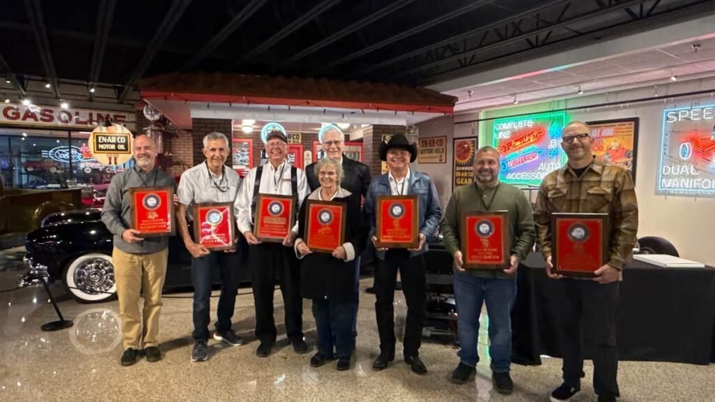 Doug Jerger (green shirt) with the 2026 class of Hall of Fame inductees and their plaques at the Museum of American Speed